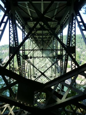 The underside of a metal bridge is a maze of metal going in many directions