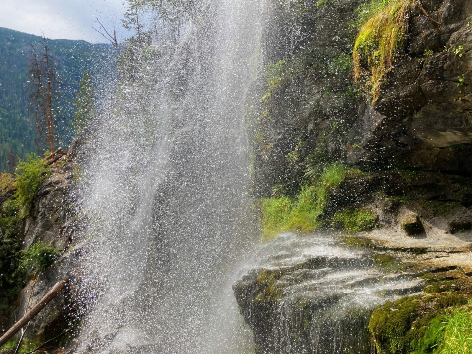 Spray from Silver Falls in the Entiat River Valleyl comes down a steep rock cliff. Some of the rocks are moss covered.