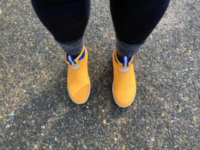 Looking down at a pair of yellow boots on a sidewalk