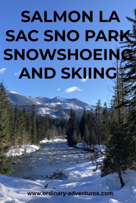 Forested and snowy distant low mountains with an evergreen forest and snow around a river. Text reads: Salmon la sac sno park snowshoeing and skiing